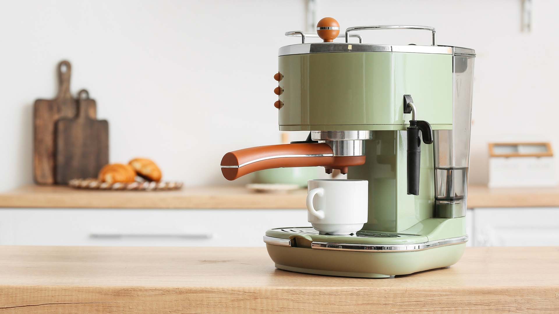 a green coffee machine on a wooden worktop