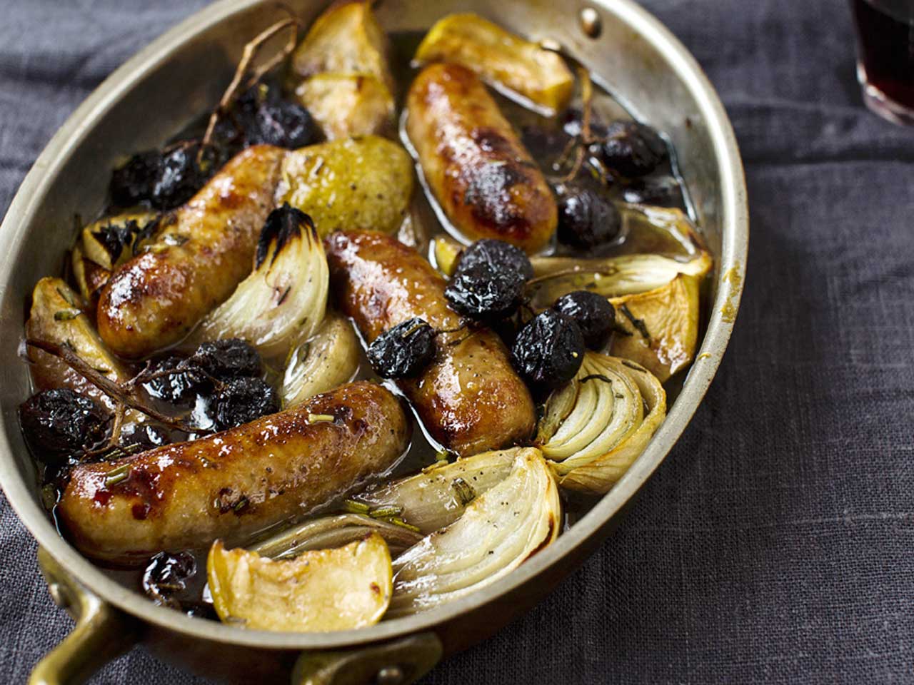Sausages roasted with apples, grapes and sherry