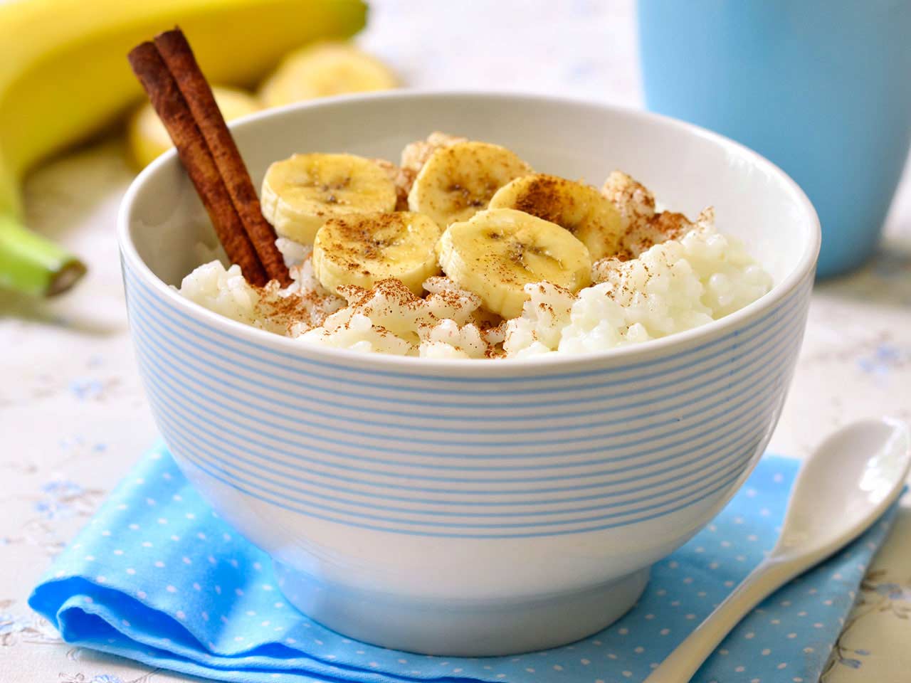 Bowl of porridge with banana and cinammon sticks