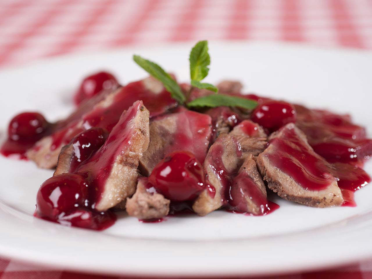 Duck breast with cherries on a place on table