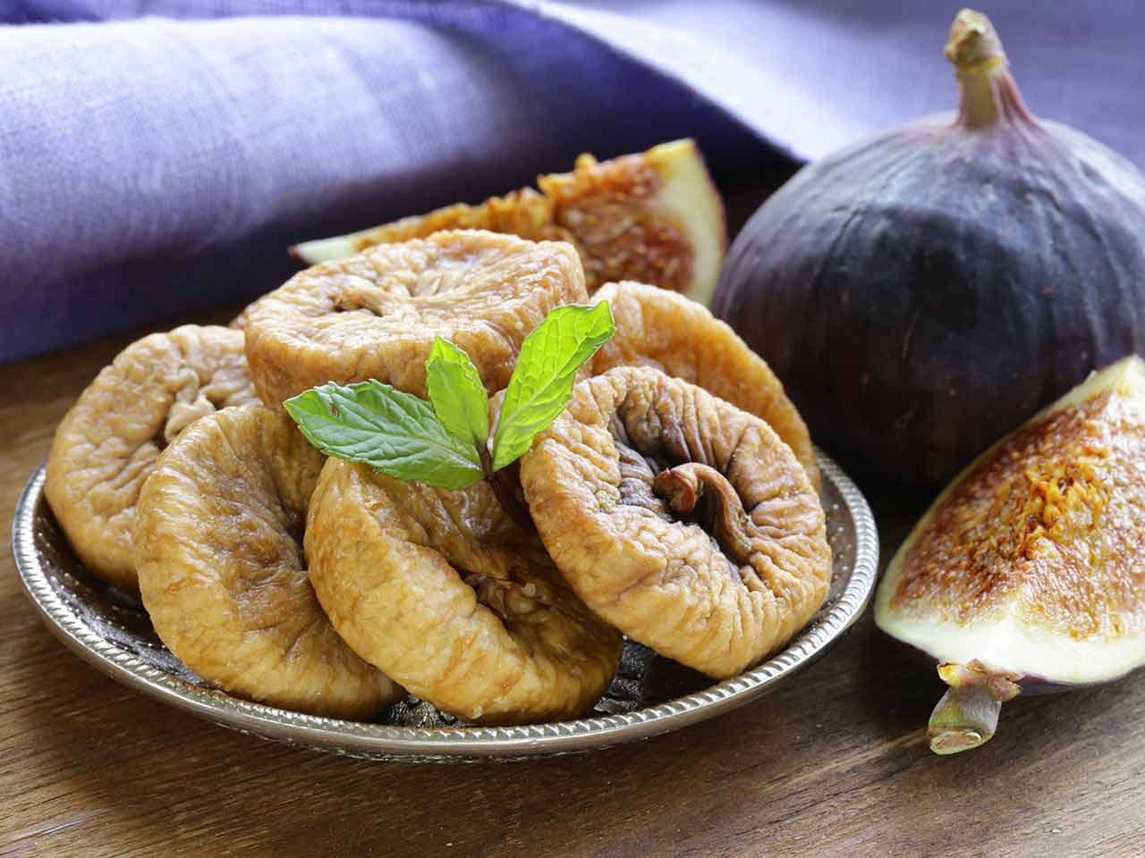A plate of dried figs and a fresh fig