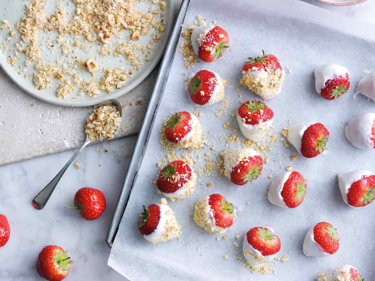 Strawberries dipped in yoghurt and hazelnuts