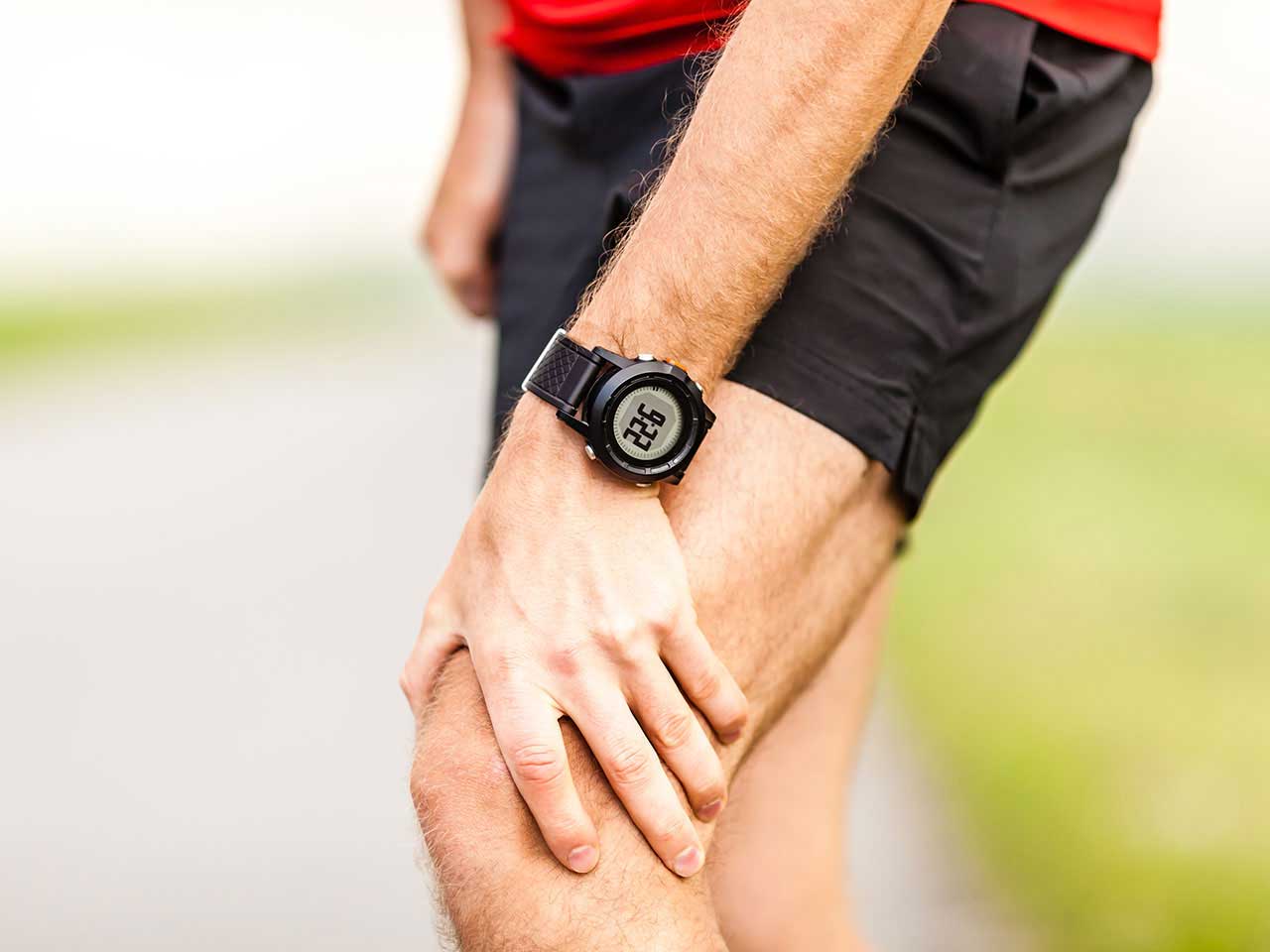 Male runner holding knee for pain relief