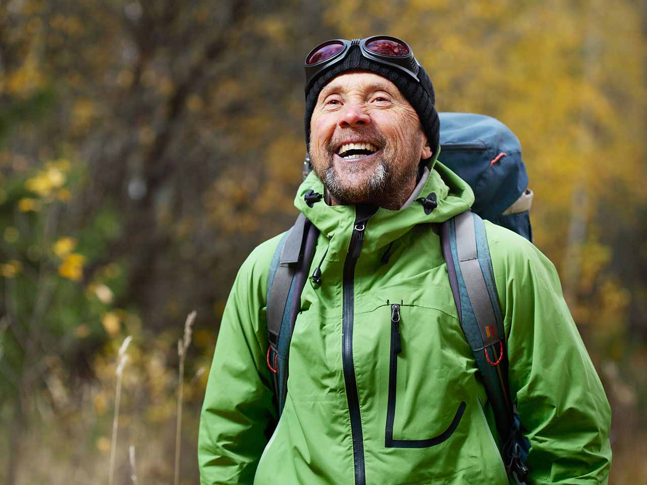 Mature man hiking with backpack and laughing