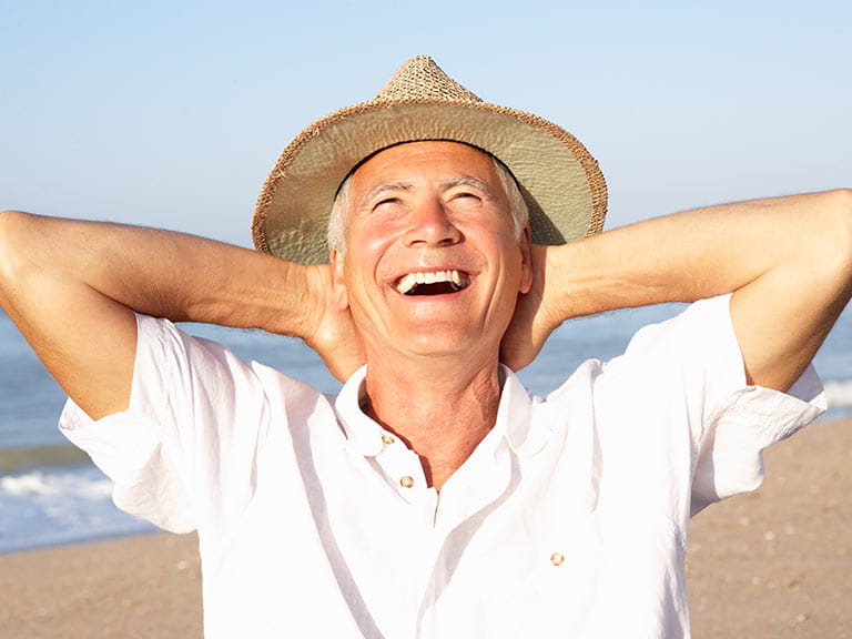Senior man laughing on the beach