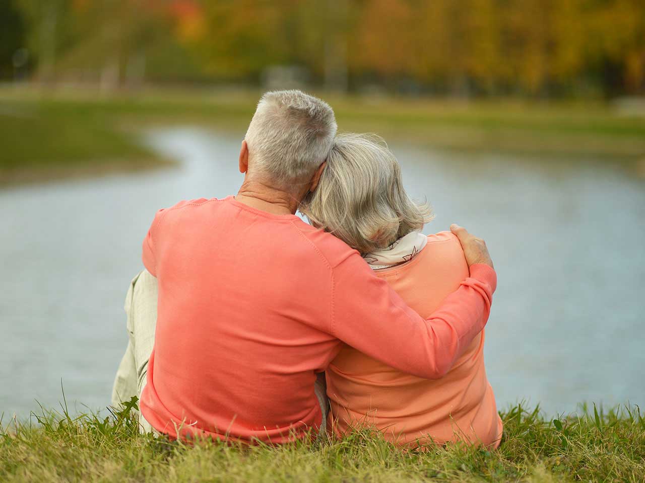 Mature couple looking thoughtful by a lake