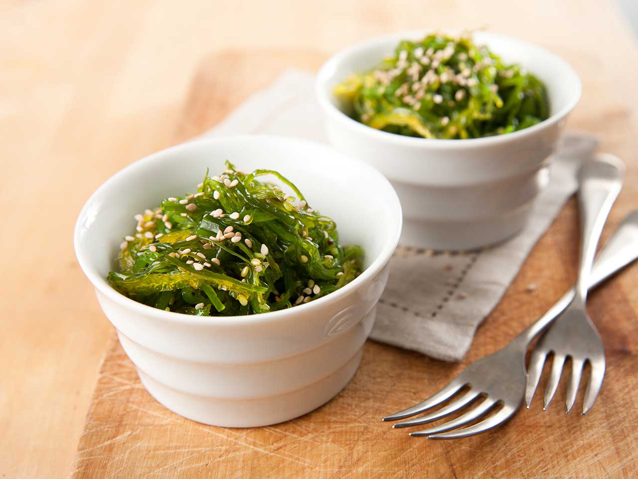 Two bowls of seaweed with sesame seeds