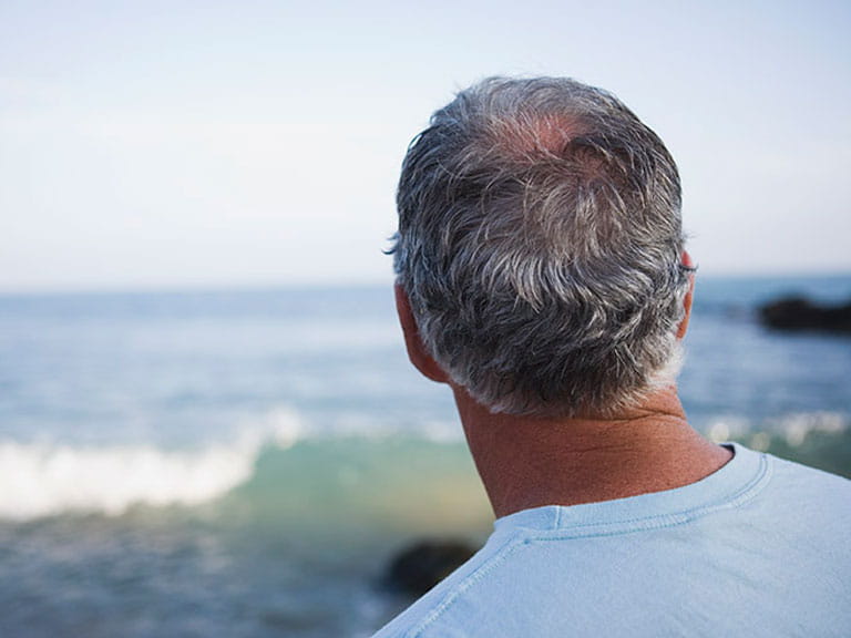 Middle-aged man looking out to sea