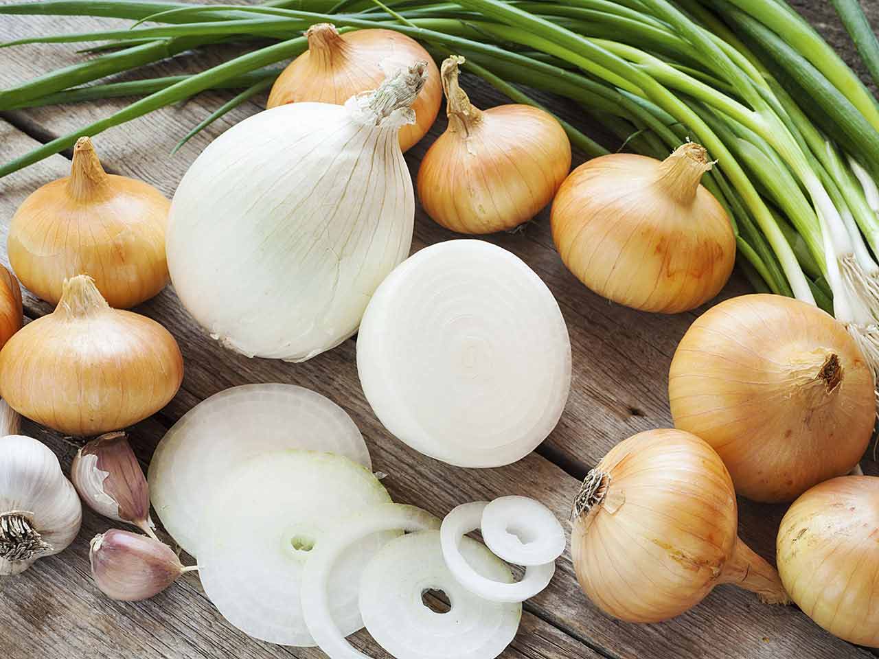 Yellow onions and garlic on chopping board
