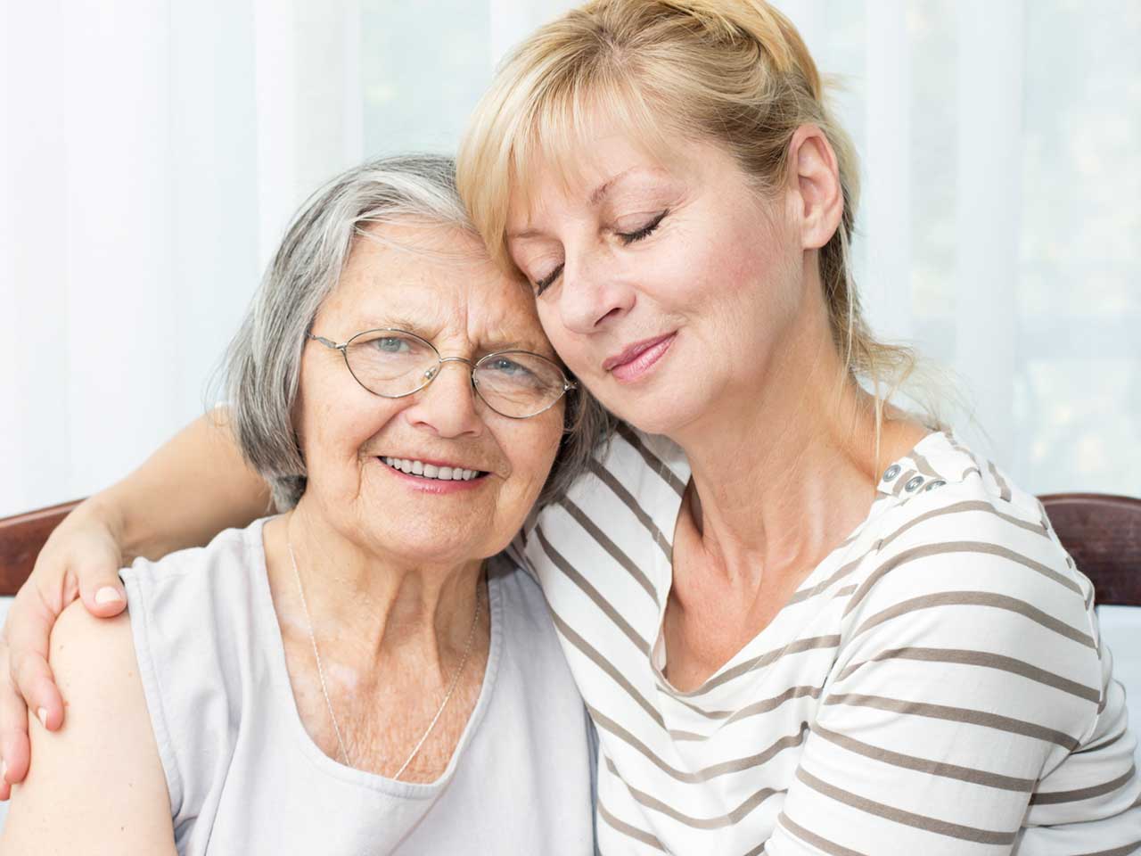 Woman hugging her elderly mother