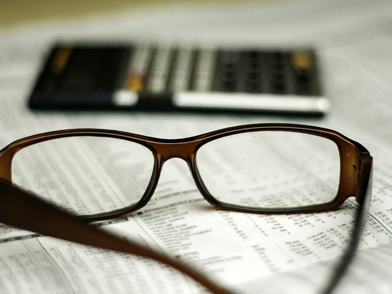 Glasses with calculator and financial paper