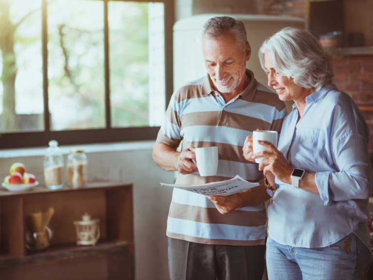 An older couple enjoying a coffee together in their kitchen