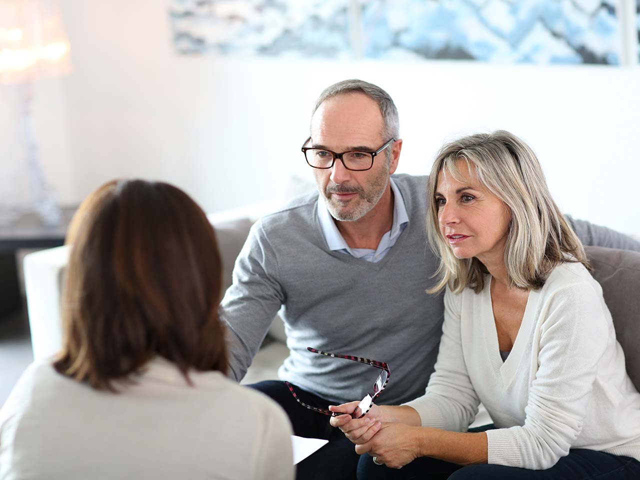 Mature couple talking to mortgage advisor