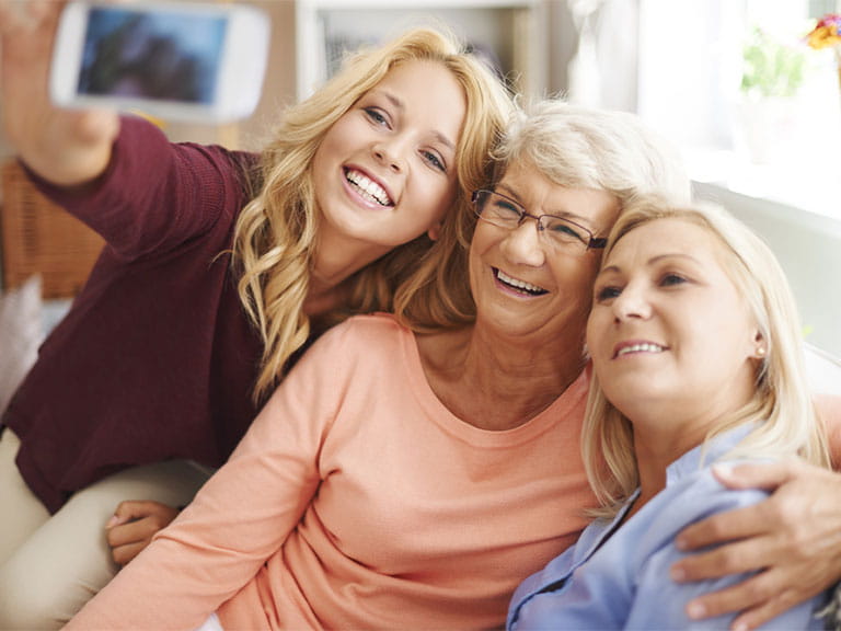 Senior woman taking selfie with daughter and granddaughter