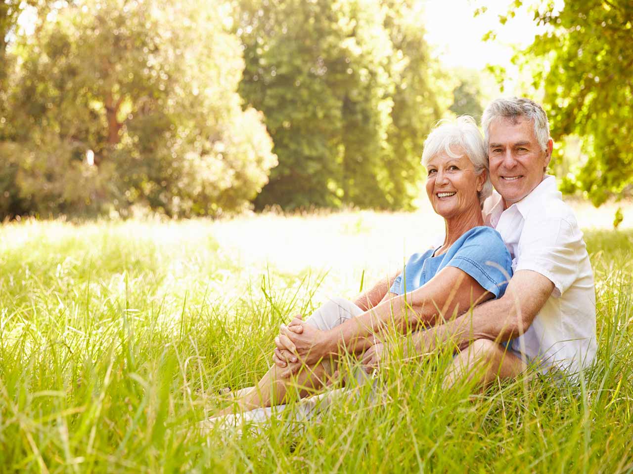 Mature couple sat in field