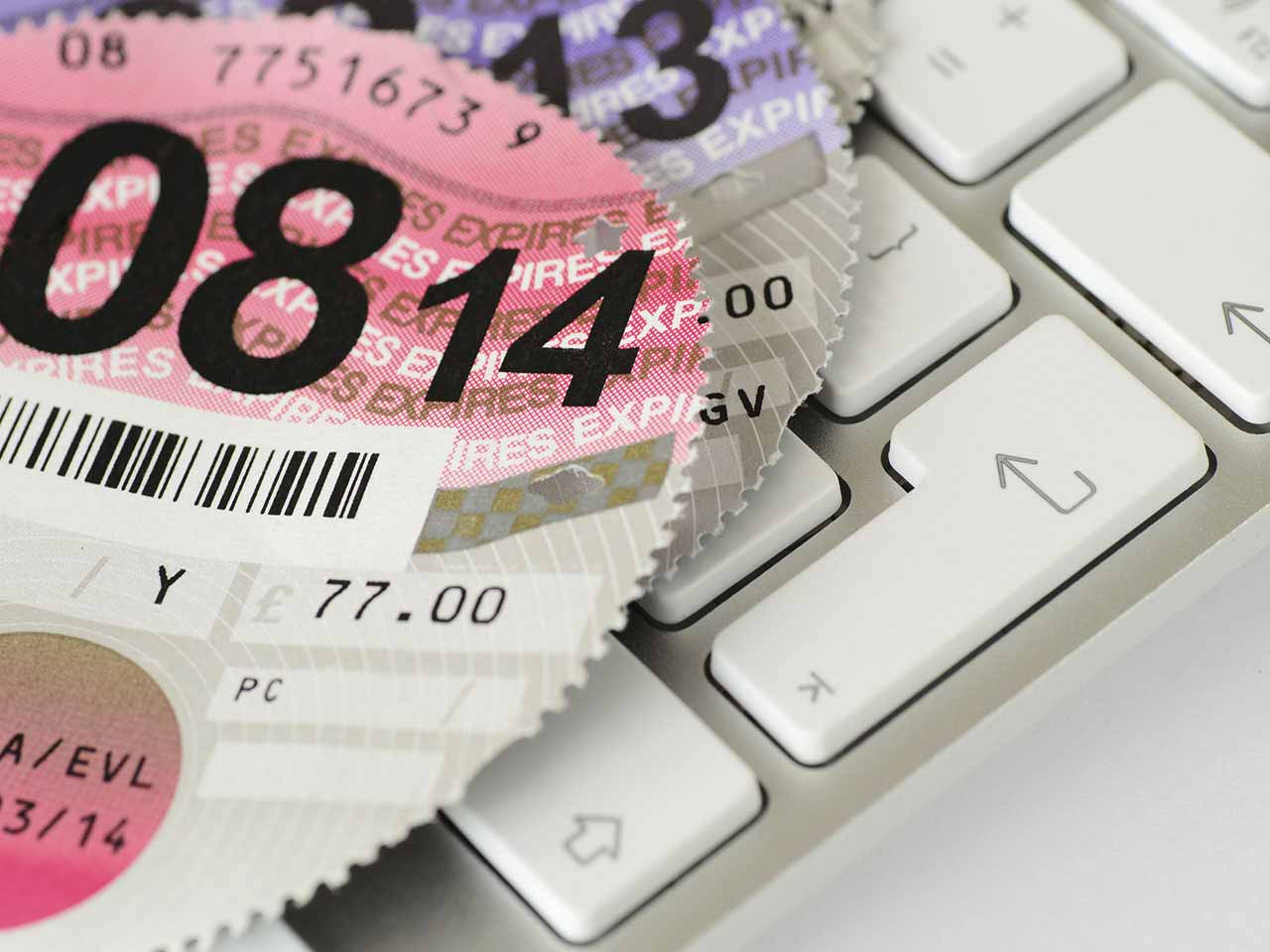 Road tax discs on a computer keyboard to represent the car tax refund email scam