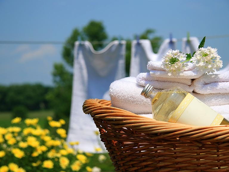 Basket of clean towels and washing online in the garden