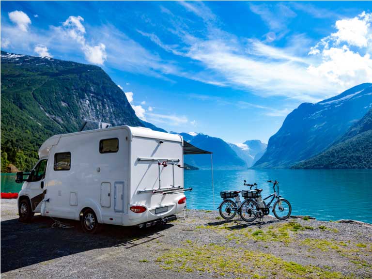 Motorhome and two bicycles parked next to Norwegian fjord 