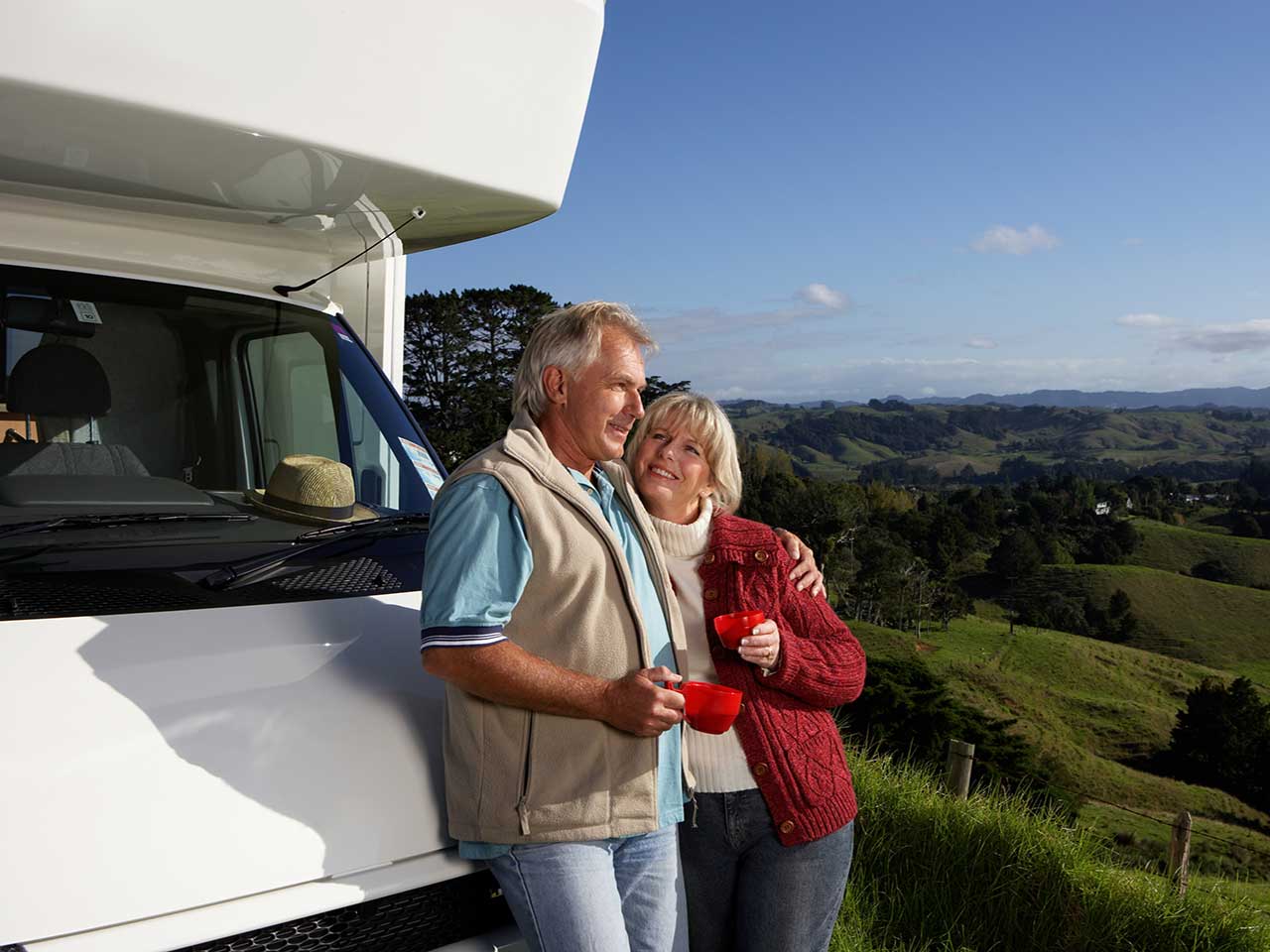 Mature couple leaning on a motorhome