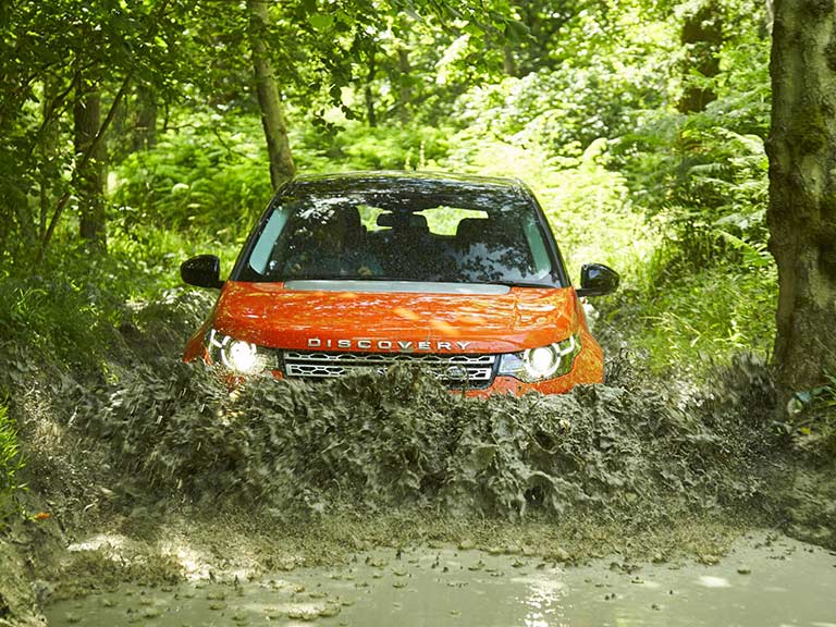 Land Rover Discovery Sport driving through mud