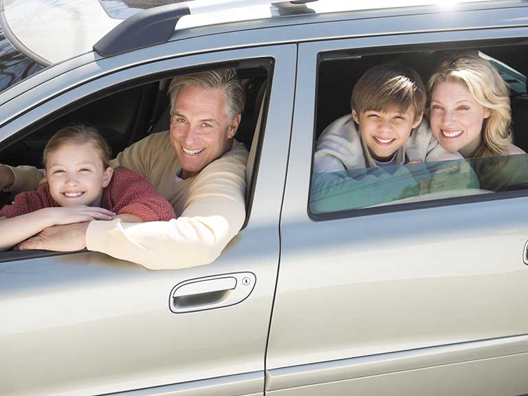 A family in a car, smiling because they are not bored