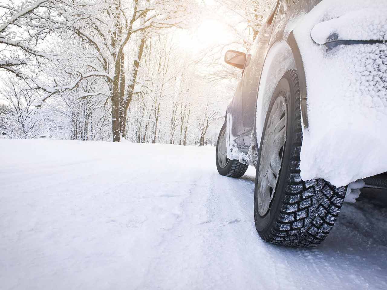 Car tyre against a winter road backdrop