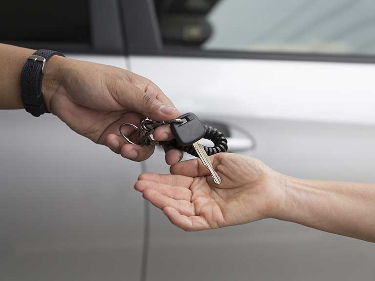 Handing over car keys to represent a car owner donating the car to charity