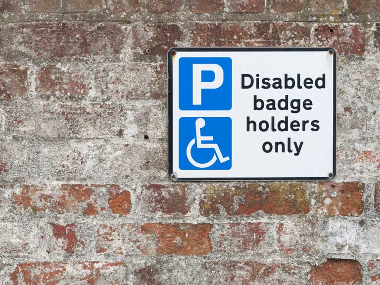 Disabled parking space sign on brick wall