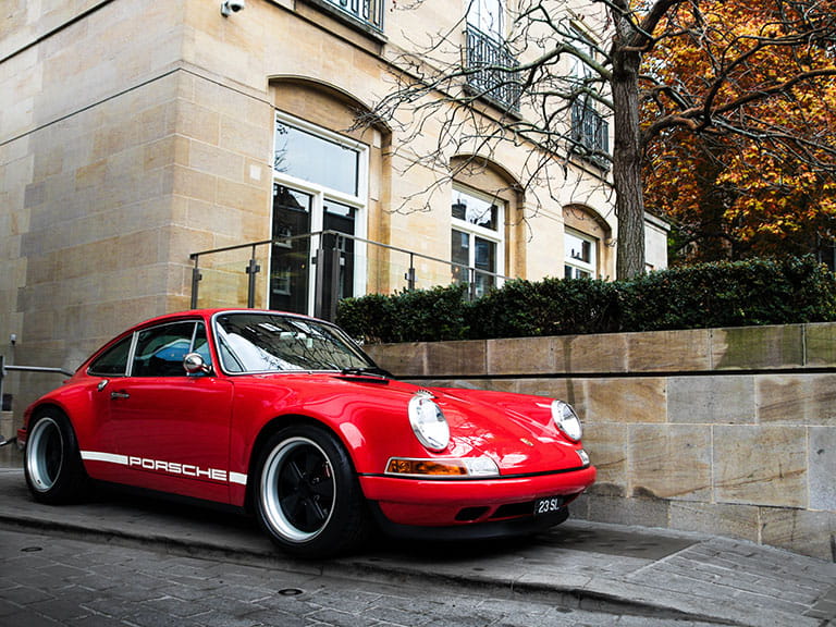 A red Porsche parked on the pavement