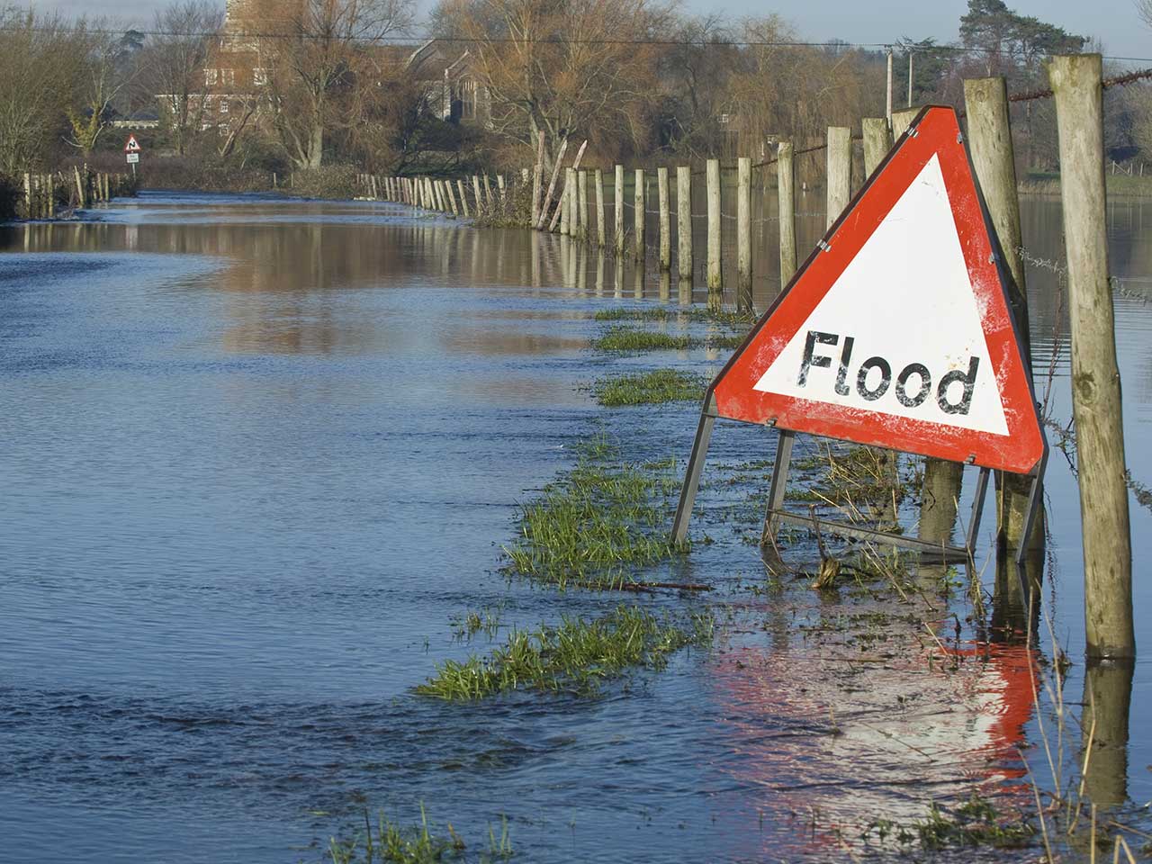 Flooded road with warning traffic sign