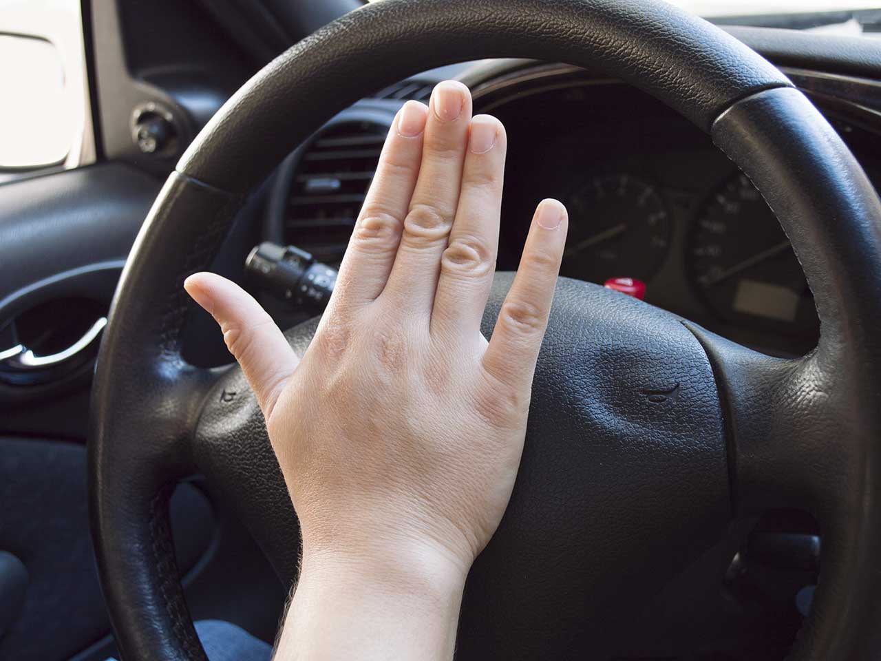 Driving slamming fist on the car horn to show frustration in an act of road rage