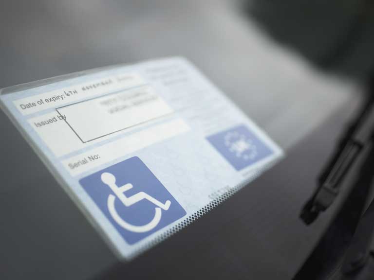 Disabled blue badge on display in a parked car