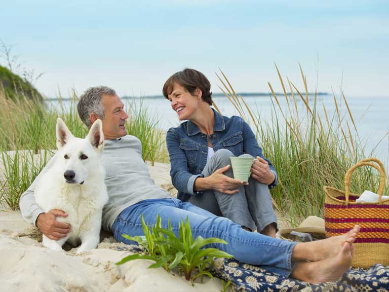 Mature couple with dog on beach