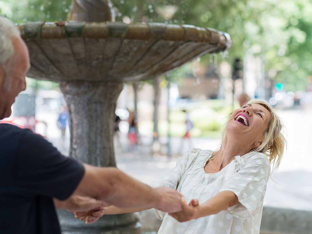 Happy mature couple embracing by a fountain