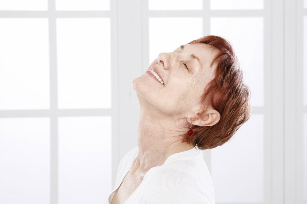 Older woman laughing, showing her neck