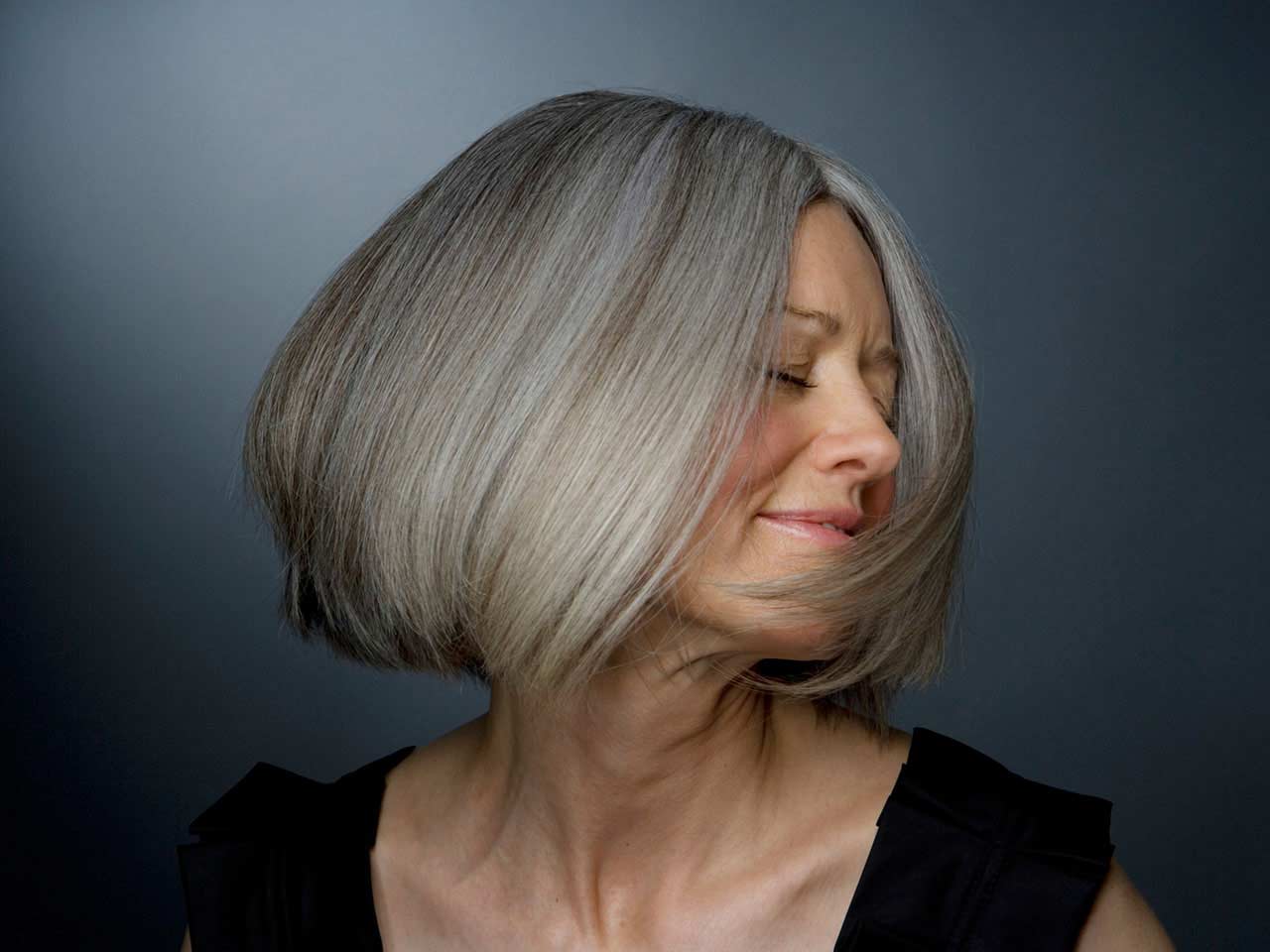 Mature lady with a grey bob swinging her hair