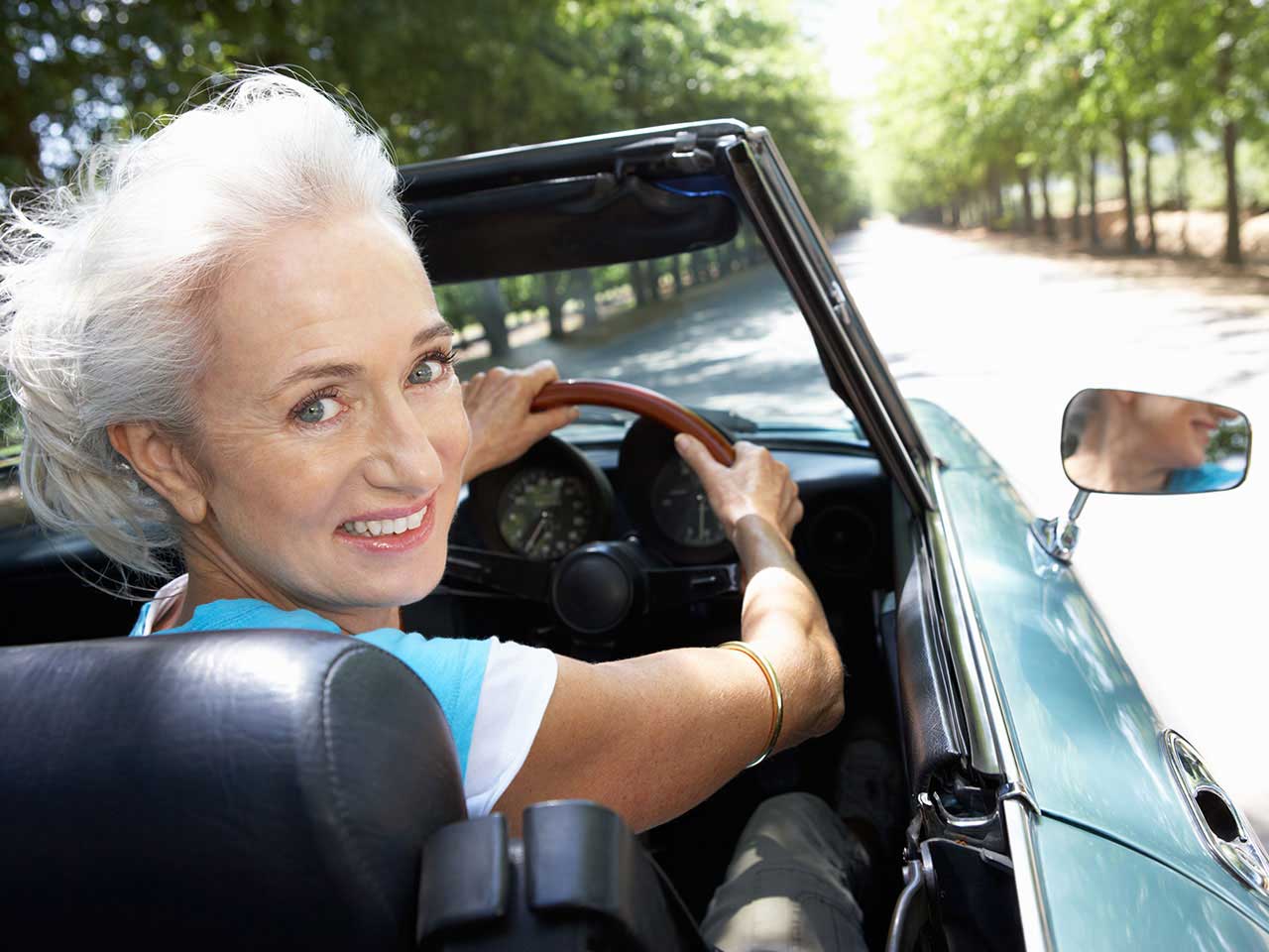 Senior lady driving sports car in the summer
