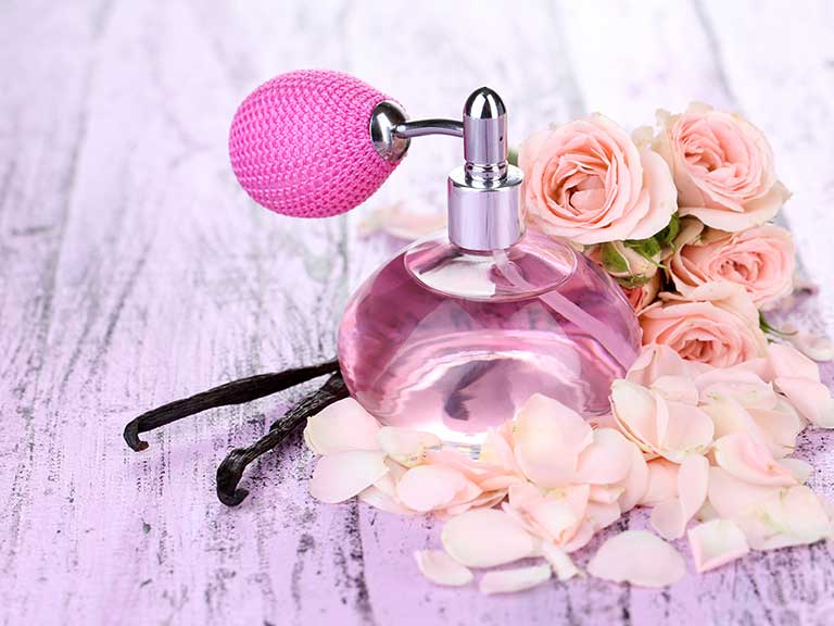 Pretty pink perfume bottle surrounded by flowers