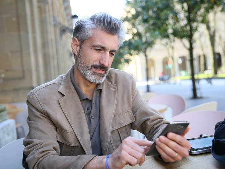 Mature grey haired man using mobile 