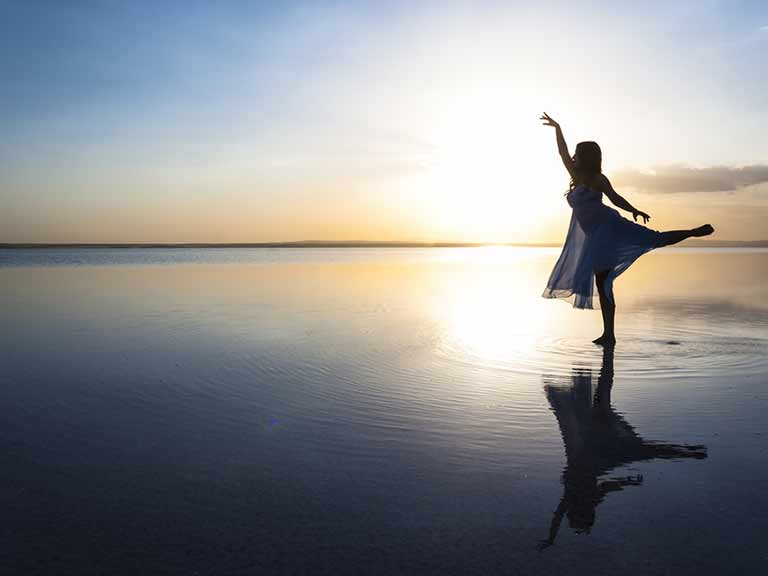 A dancer with good posture poses in the sunset