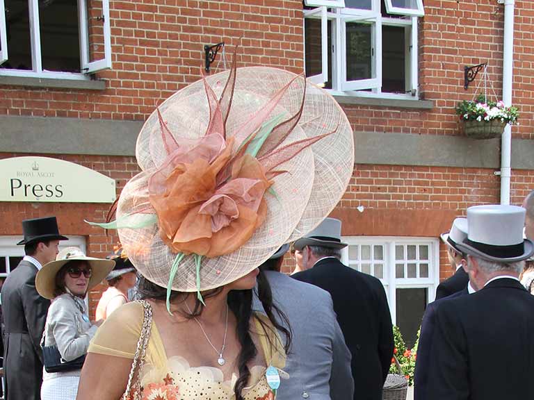 A woman wearing a big hat attends Royal Ascot