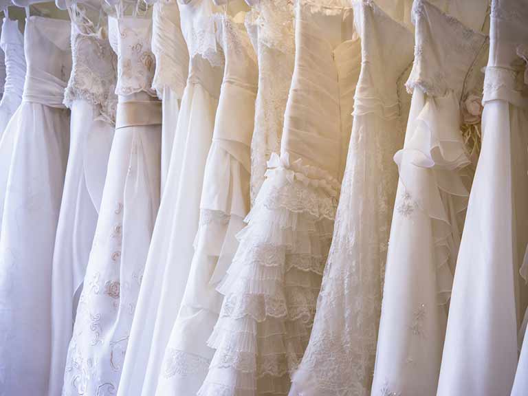Wedding dresses hanging on a rail in a bridal boutique