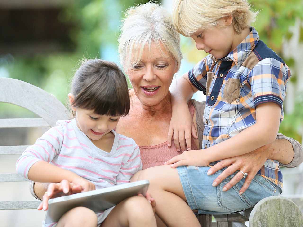 Grandma and grandchildren using tablet