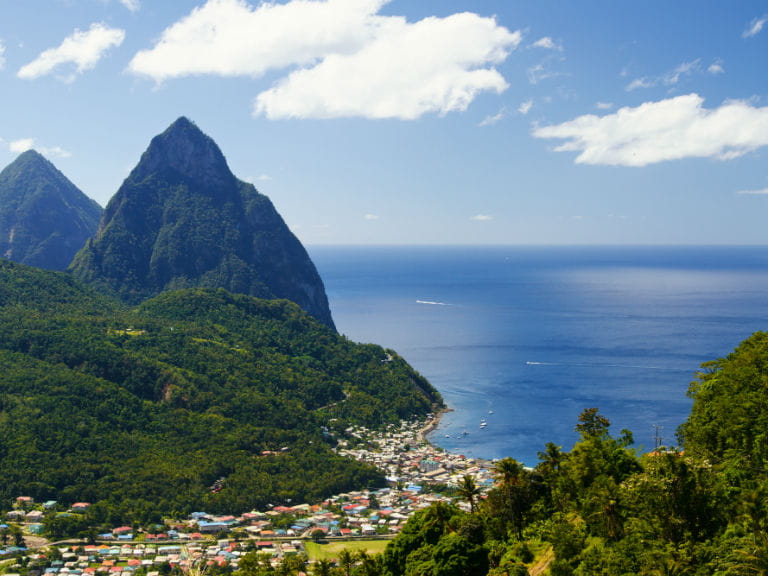 The town of Soufrière in Saint Lucia, with the Pitons, two mountainous volcanic plugs, in the background