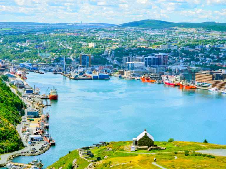 Panoramic views with bight blue summer day sky with puffy clouds over the harbor and city of St. John's NewFoundland, Canada.