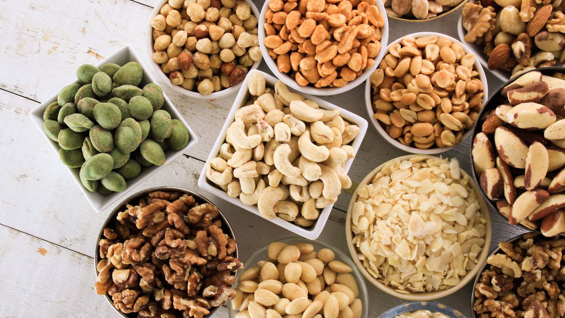 A selection of different nuts in bowls on a table