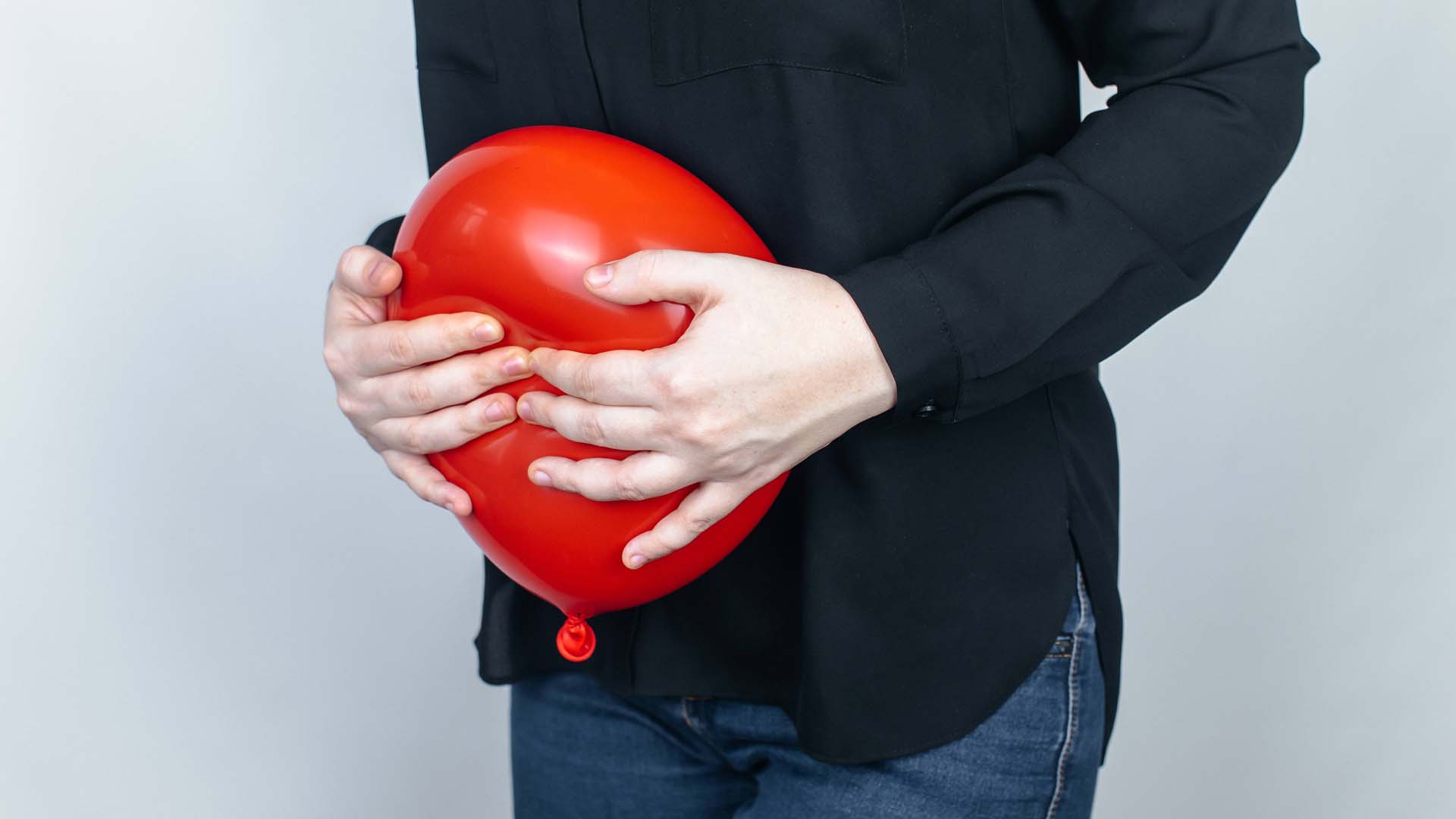 A man with an inflated balloon against his stomach