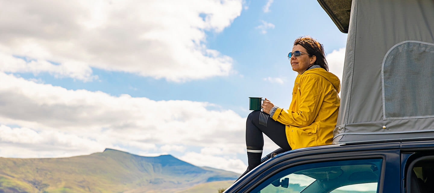 Woman sitting on campervan in the Brecon Beacons