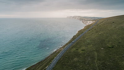 Car driving along a road on the Isle Of Wight coastline