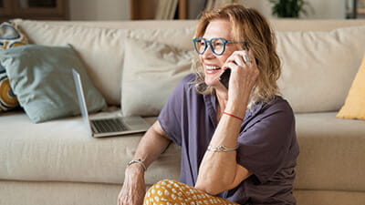 A mature woman talking at home on her mobile phone